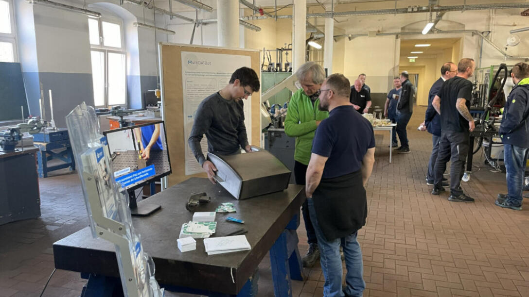 Besucher stehen vor einem Ausstellungsstand