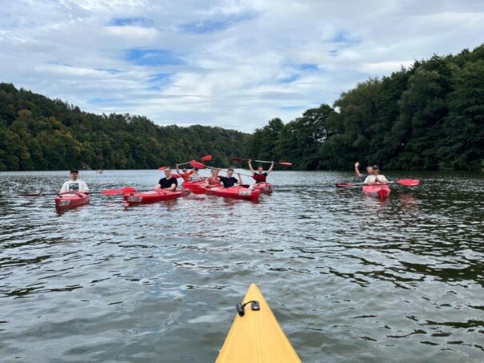 Personen sietzen in Kanus auf dem Wasser