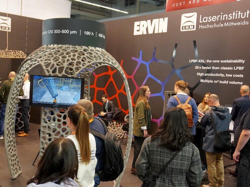 Besucher an einem Messestand mit einem Pavillon