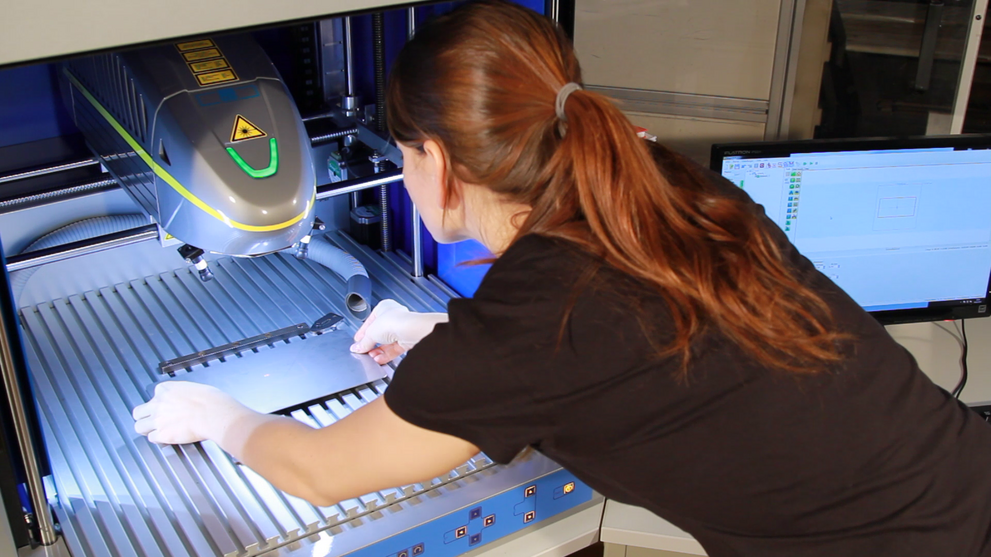Eine Studentin bedient eine Laserbeschriftungsanlage