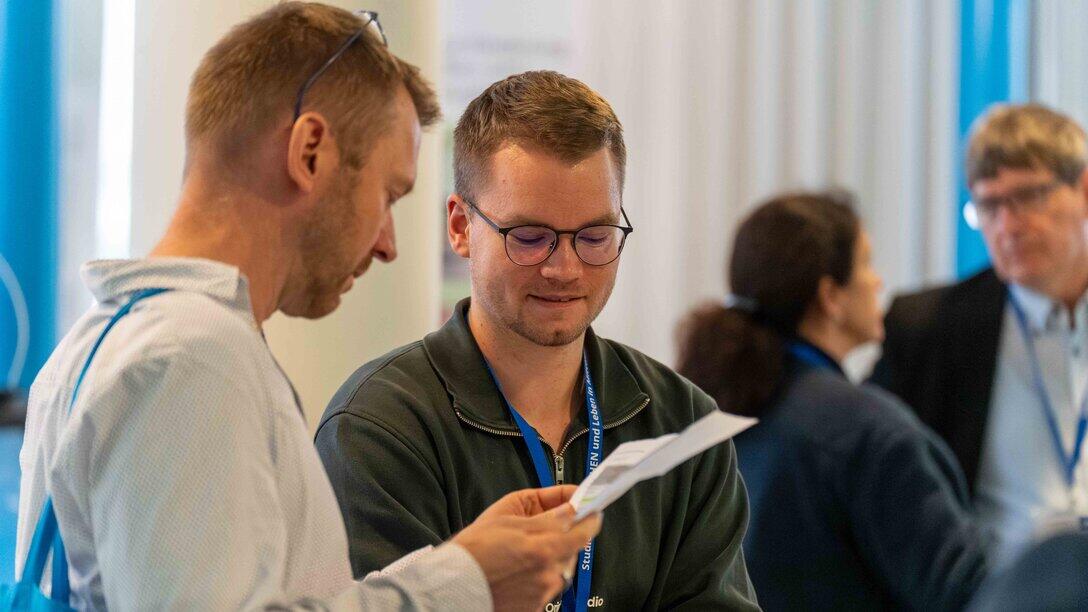Zwei männliche Personen ins Gespräch vertieft