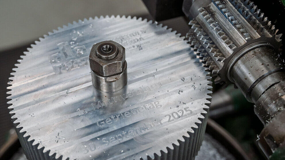 A close-up of the tool and the workpiece, a gear. The text ‘1st Mittweida Gear Conference. 30 September 2025’ is engraved on it.