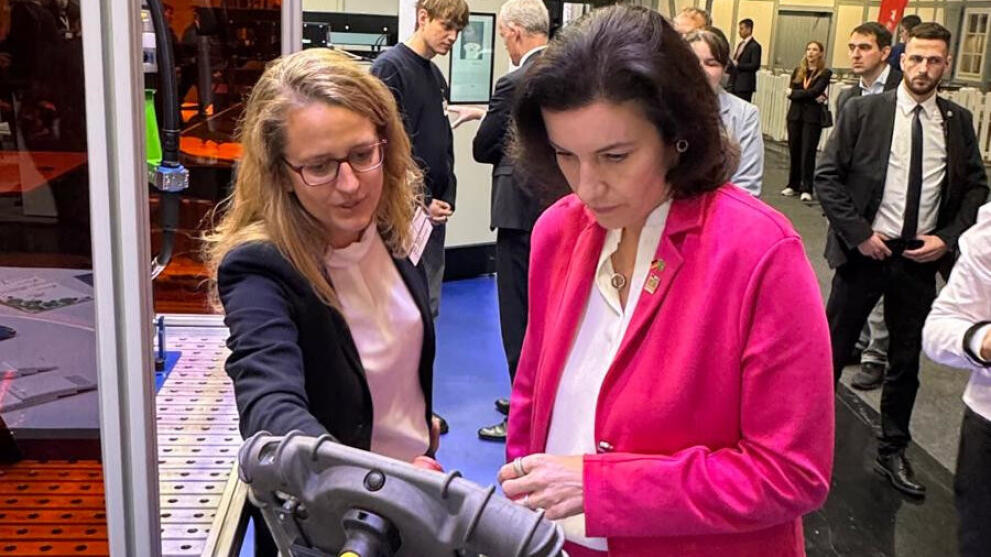 Zwei weibliche Personen stehen am Schweißroboter und bedienen ein Tableau