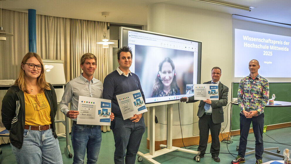 5 Personen stehen vor Präsentationstafel