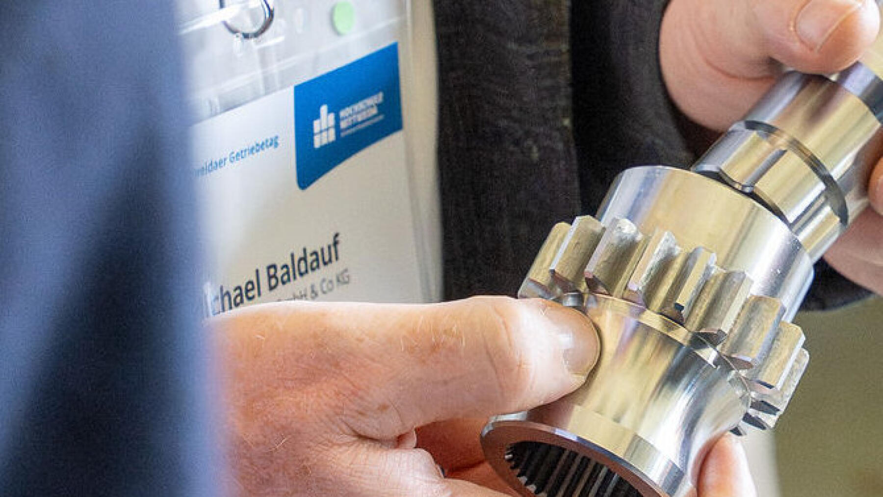 zwei Hände halten ein Getriebe