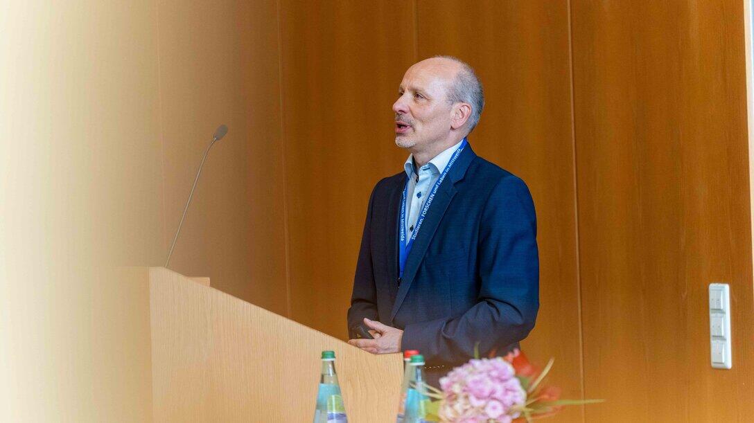 Eine männliche Person steht hinter einem Rednerpult