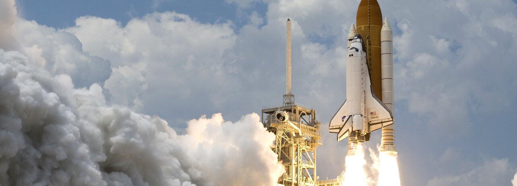 Eine Rakete hebt mit Trägerbooster und einem Feierschweif ab