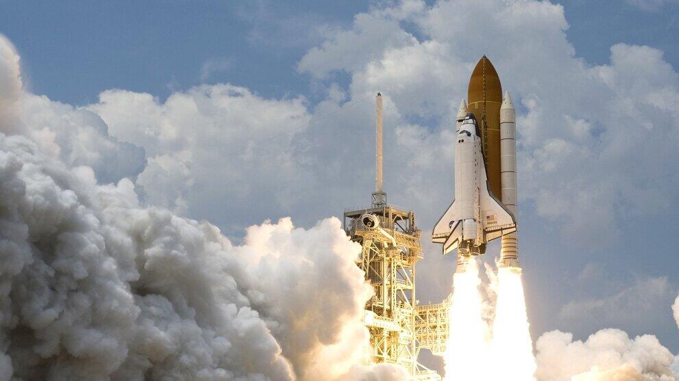 Eine Rakete hebt mit Trägerbooster und einem Feierschweif ab