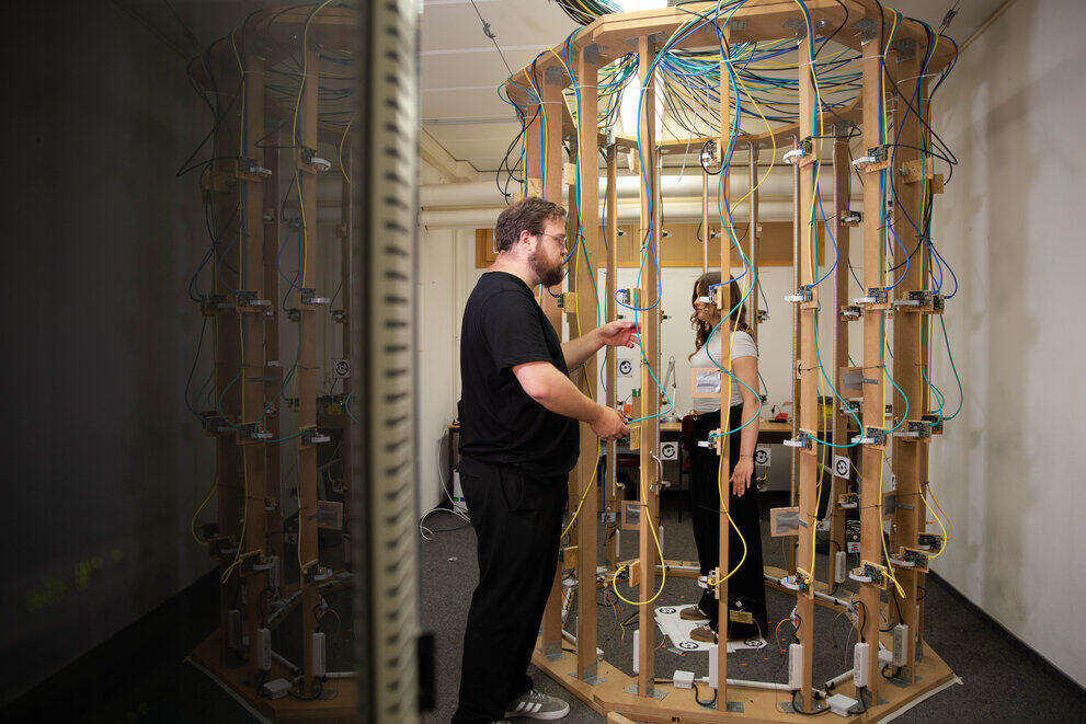 Ein Student macht einen 3D-Scan einer anderen Studentin mit einer Scannerkabine.