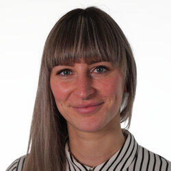 Eine Frau mit langen blonden Haaren und Nasenring schaut freundlich in die Kamera.