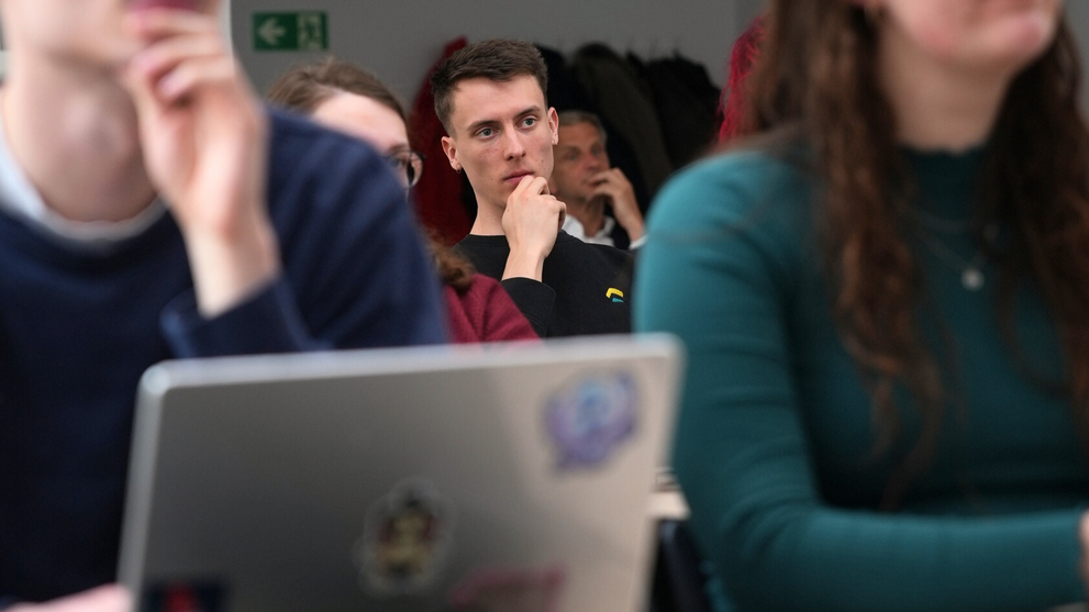 Several students are watching and listening.