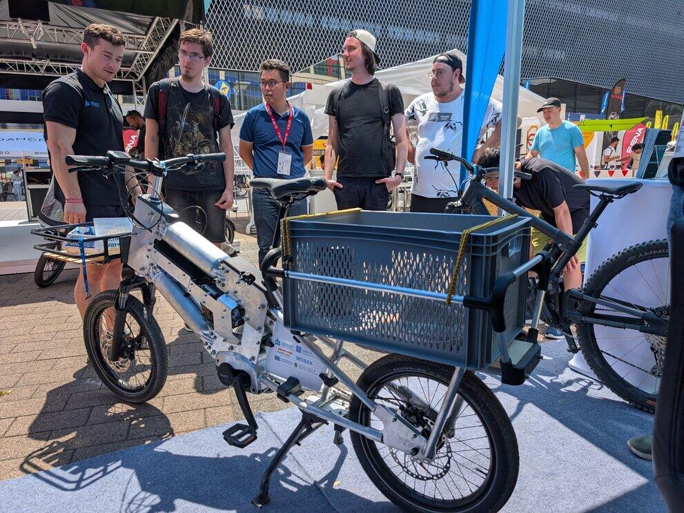Vier Personen stehen hinter einem Lastenrad