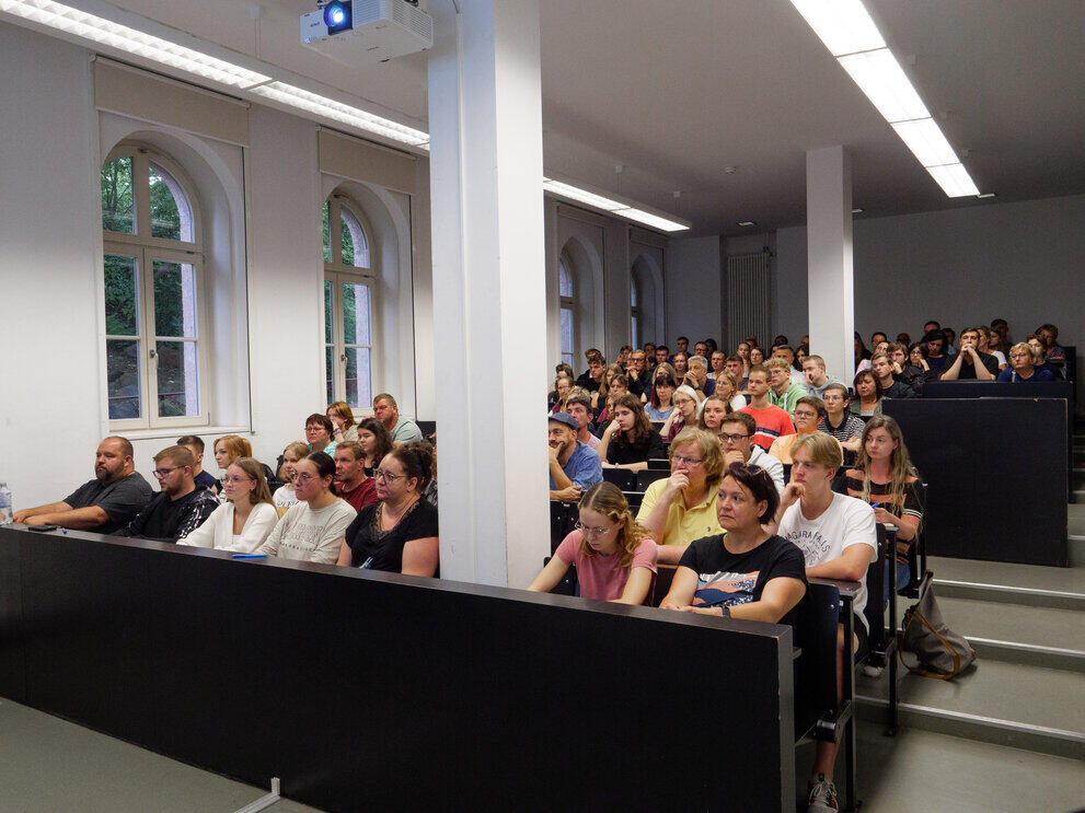 Besuchende sitzen im Hörsaal für den Vortrag "Wie funktioniert Studieren?".
