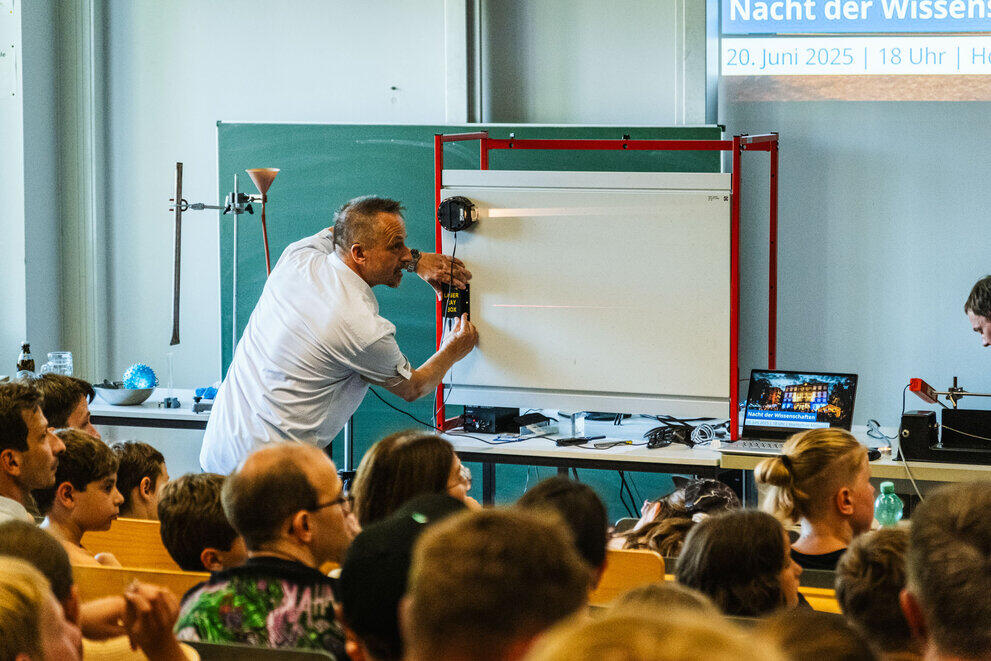 In the physics demonstration lecture, a professor demonstrates experiments involving light and lasers.