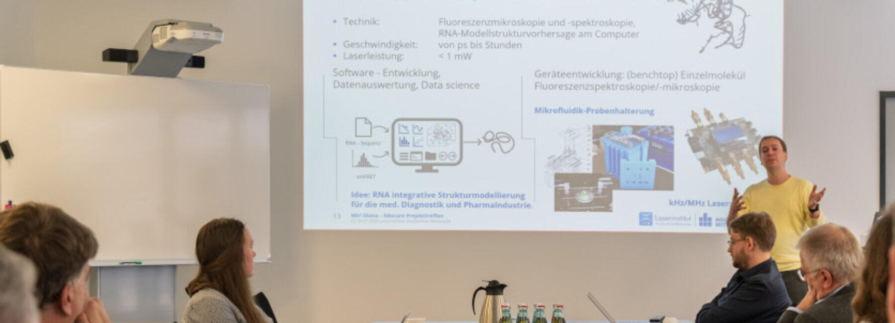 männliche Person steht vor Präsentationswand
