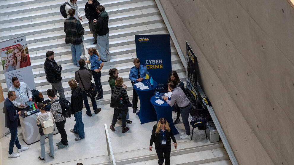 Blick auf Treppe mit Firmenständen und Personen