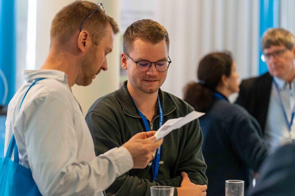 Zwei männliche Personen ins Gespräch vertieft
