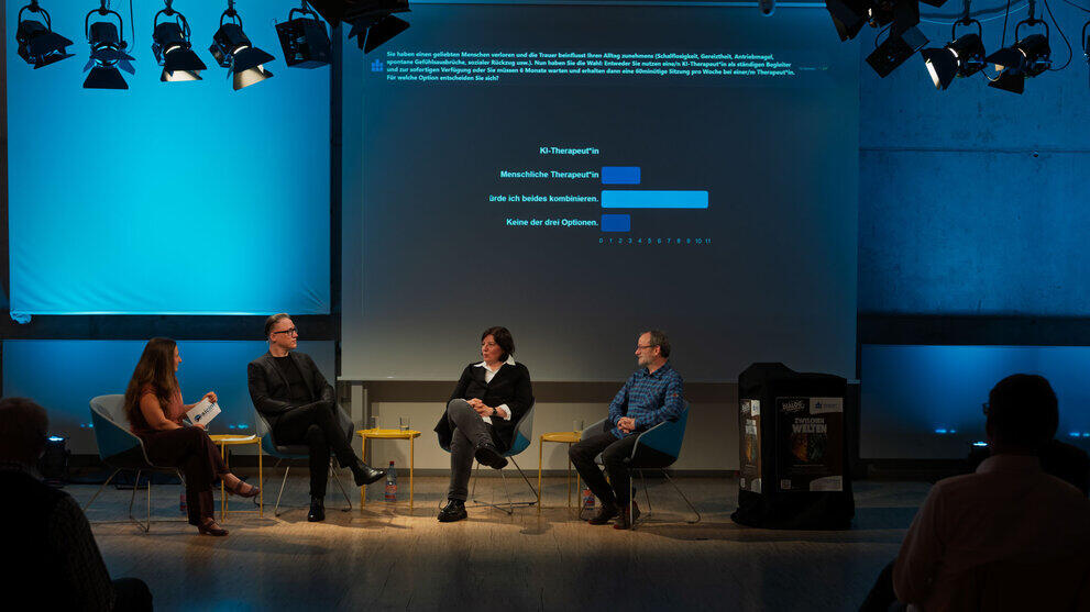Ein Diagramm auf der Leinwand hinter dem Podium zeigt live das Abstimmungsergebnis der Publikumsfrage: Die Mehrheit würde KI und die:den Therapeut:in kombinieren.