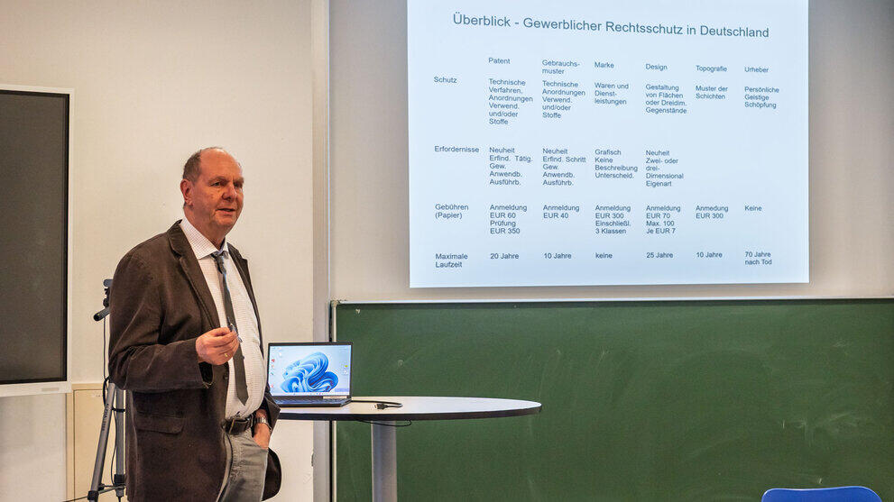 männliche Person steht vor Präsentationstafel