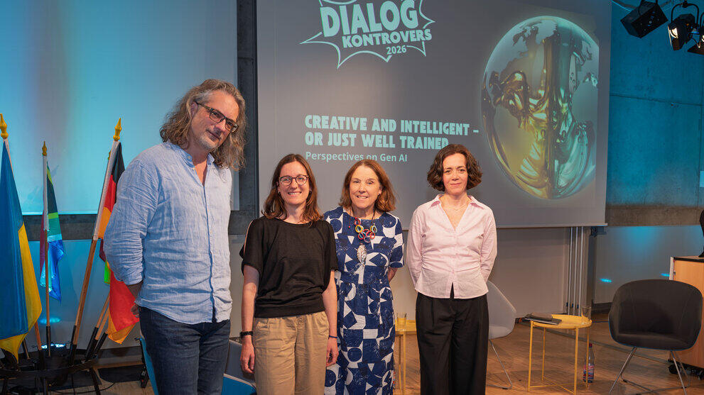 Gruppenfoto mit den drei Podiumsteilnehmeden und der Moderatorin