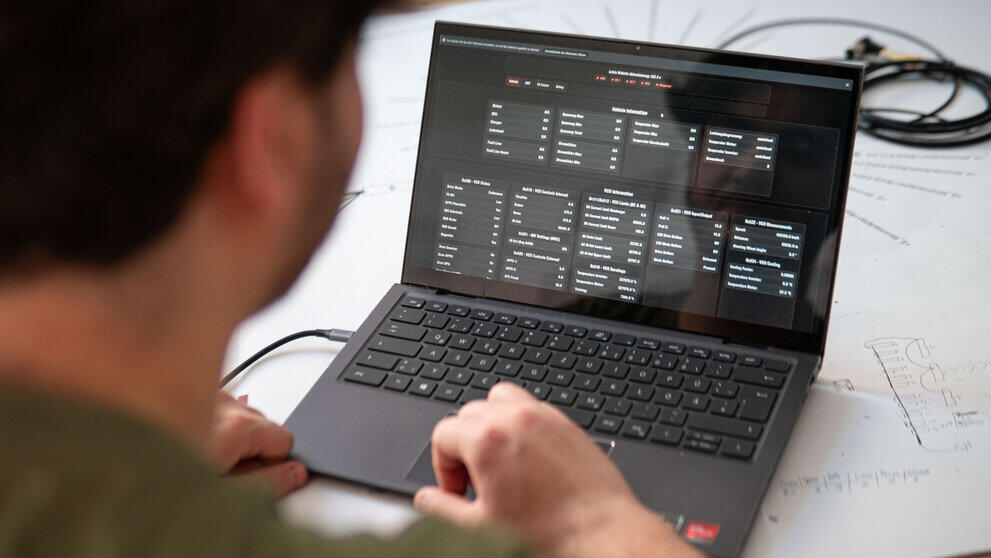 Aufgeklappter Laptop, auf den eine Person blickt. Es sind nur tabellenartig angeordnete Werte zu sehen.