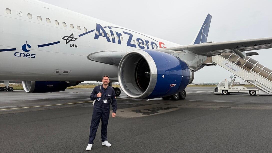 Ein Mann steht vor dem Triebwerk eines Jets